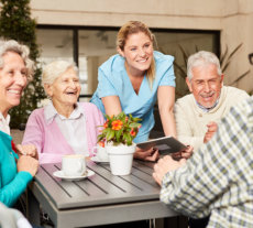 group of seeniors laughing with their nurse