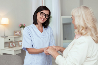 nurse and senior woman are smiling together