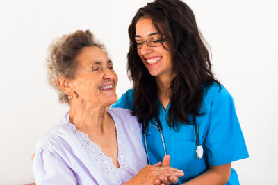 nurse and senior woman laughing